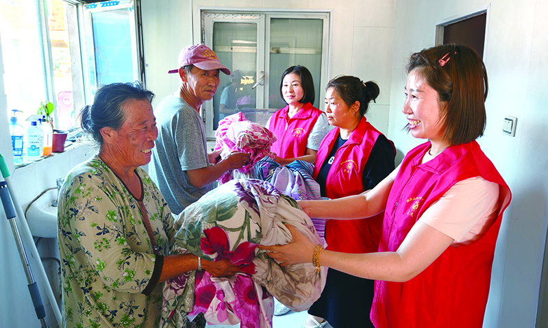 高齡老人將需要清洗的衣物送到愛心洗衣房